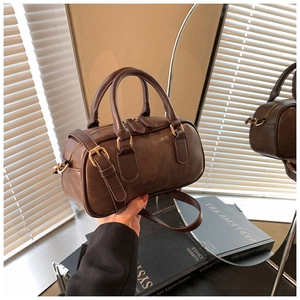 Detail of vintage brown mini Boston bag with retro matte faux leather and gold hardware