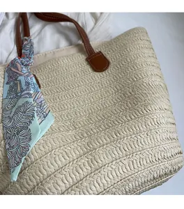 Detail of straw woven tote bag featuring high-density texture and silk scarf decoration