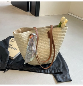 Detail of woven straw tote with leather handles, vintage silk scarf and floral decor