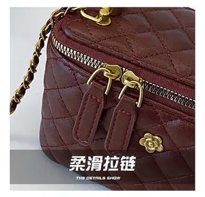 Dettaglio della cerniera dorata e della pelle trapuntata bordeaux della borsa