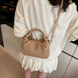 Chic pleated beige leather handbag with dual circular handles and detachable shoulder strap