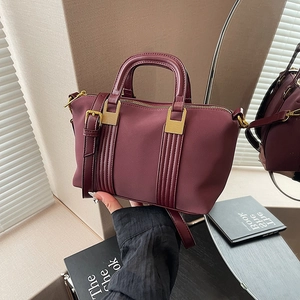 Elegant wine red Boston tote bag with gold hardware and adjustable shoulder strap