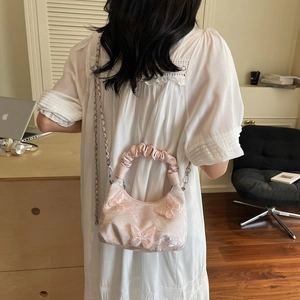 Pink lace handbag with 3D embroidery butterfly detail and ruffled handle shown on model
