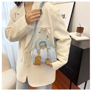 Detail of light blue Boston bag with lychee texture and metallic chain decoration