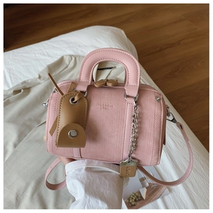 Pink Boston handbag detail showing cross-grain leather texture and embossed logo