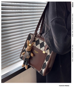 Detail of rhombic pattern tote bag with leather pocket and brown knit bunny charm