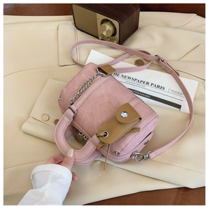 Detail of pink Boston bag with textured fabric, adjustable strap and decorative mini pouch