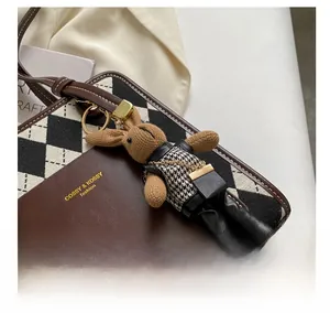Detail of dark brown leather handbag with argyle pattern and stylish rabbit charm