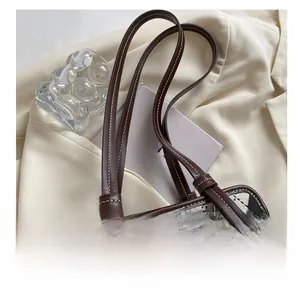 Detail of comfortable brown leather shoulder straps with contrast stitching on tote bag