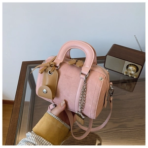 Detailed shot of a pink mini Boston bag with JNI & fashion 1997 embossing and handle