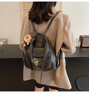 Detailed back view of a black tote backpack with lion charm in a retro modern setting
