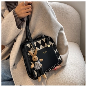 Black and white argyle tote bag featuring a leather pocket and knit bunny charm