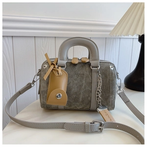 Detail of vintage denim Boston bag with grey leather straps and mini pouch accessory