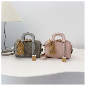 Detail of vintage green and soft pink Boston barrel bags with adjustable straps and tags