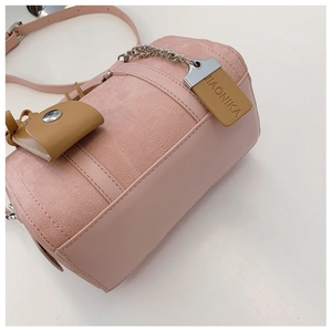Detail of pink cylindrical Boston bag with leather trim and silver metal chain strap