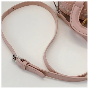 Detail view of pink Boston bag showing adjustable leather shoulder strap and silver buckle