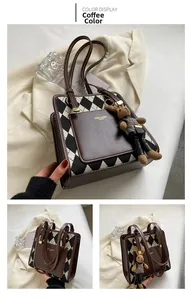 Close-up of vintage brown leather tote with knit argyle pattern and bunny charm