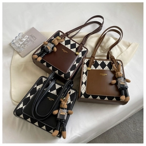 Detail of retro quilted tote bag with leather pocket and cute plush bunny pendant