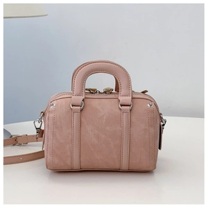 Detail of soft pink mini Boston bag with textured leather and adjustable shoulder strap