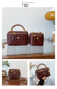 Close-up of burgundy quilted bucket bags with golden floral hardware and chain straps