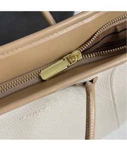 Détail de la couture en cuir grainé et de la fermeture éclair dorée du sac cabas