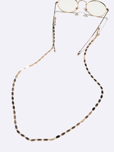 Detail of gold metal oval-link eyewear chain attached to round glasses frames