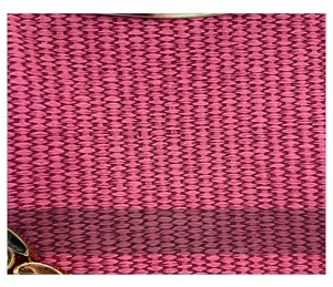 Macro detail of magenta woven fabric texture on a fashion bag with gold metal frame