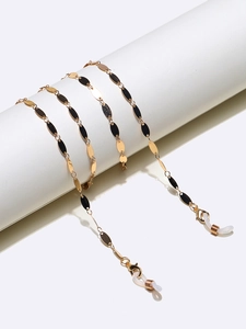 Detail of gold eyewear chain with oval metal charms and non-slip silicone loops