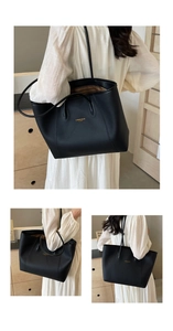 Détail du sac cabas en cuir noir grainé avec logo doré et doublure intérieure rayée