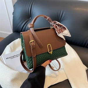 Sac à main en cuir tressé vert avec rabat marron, fermoir doré et foulard sur tweed