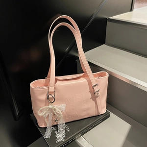 Rosa Shopper aus PU-Leder mit Reliefschrift und Perlen-Schleifenanhänger auf Treppe