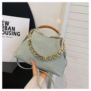 Detail view of woven handbag with wood-texture handle and diamond-encrusted gold chain strap