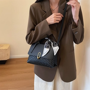 Sac à bandoulière noir élégant avec base tressée, fermoir doré et foulard décoratif