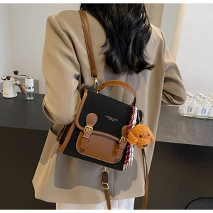 Detail view of retro backpack featuring a plush dog charm and textured leather trim