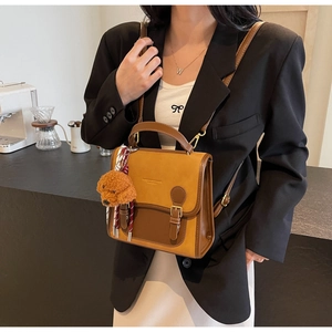 Chic retro contrast backpack with a cute teddy bear charm on model in a modern cafe