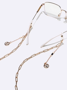 Detail of gold metal glasses chain with elegant V-letter pendant and link design