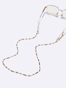 Detailed view of golden bead chain with silicone loops attached to glasses frame