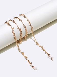 Detailed shot of golden beaded handmade eyewear chain with lobster clasps and silicone loops