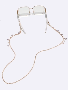 Chaîne à lunettes dorée avec perles mauves et strass sur monture fine dorée