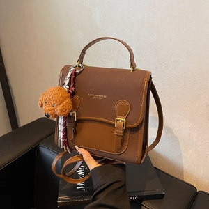 Brown vintage leather backpack for women with puppy charm and adjustable strap