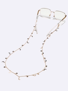 Golden eyewear chain with star and moon charms on a pair of metal glasses