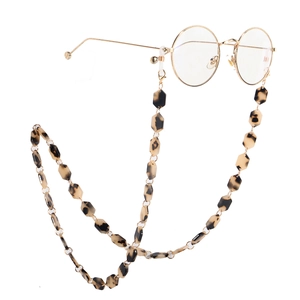 Detail of tortoise shell acrylic hexagon links on a gold chain for eyewear fashion