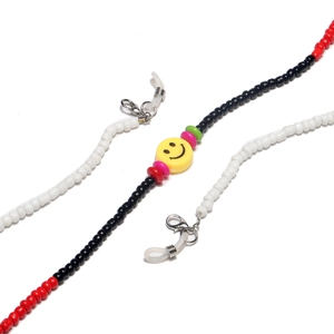 Close-up of beaded glasses chain with red, black, white beads and yellow smiley face