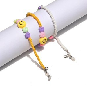 Detail of colorful beaded eyewear chains with smiley faces and flowers on white props