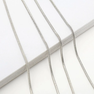 Dettaglio macro di catene a serpente in argento da 1,2 mm con finitura lucida su bianco
