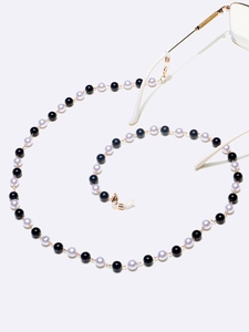 Primer plano de perlas de 8mm negras y blancas en cadena dorada para gafas con gomas