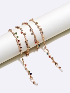 Dettaglio catenella per occhiali dorata con strass colorati e anelli in silicone