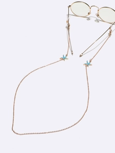 Detail of gold eyewear chain featuring blue starfish charms and silicone loops