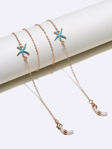 Detail of rose gold eyewear chain featuring blue starfish charms and non-slip loops