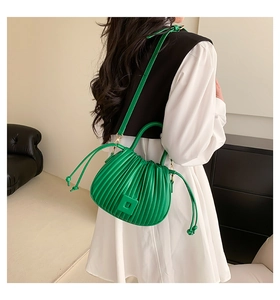 Detailed view of bright green pleated handbag with drawstring and sturdy handle